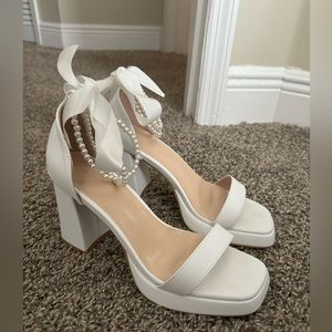 White high heels with pearls and bow